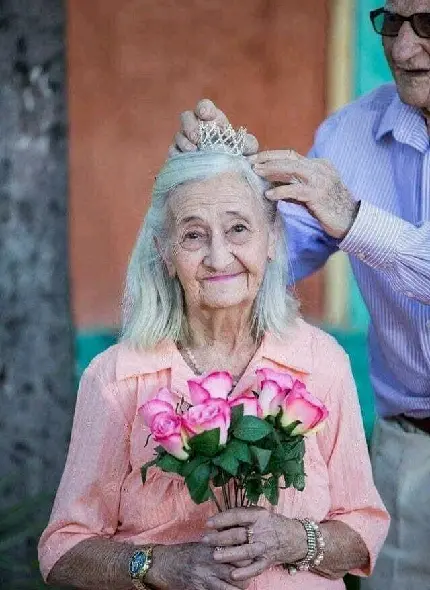 Image of an Elderly Woman Wearing a Crown with Pink Roses