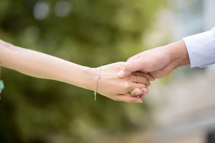 A picture of a beautiful couple holding hands at a wedding