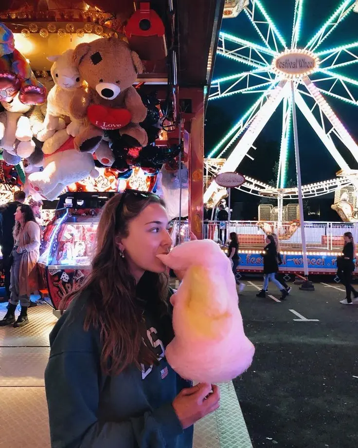 Cute girl with pink cotton candy at amusement park profile picture
