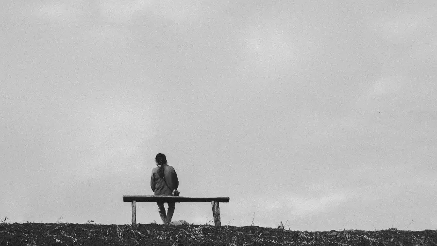 Black and White Photo of Girl Sitting Alone on Bench