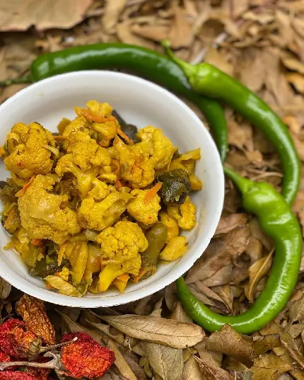 Image of yellow mixed pickles in simple bowl on autumn leaves