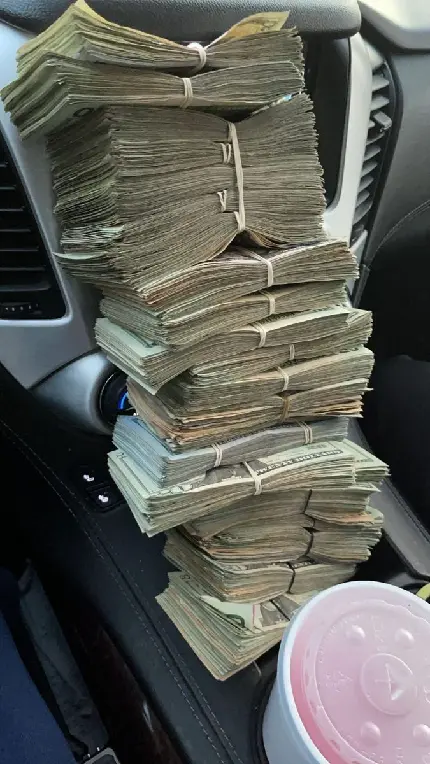 Money in luxury car photo for international laugh and get rich day