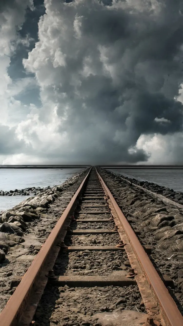 Download the background of the iPhone 14 and ios 16 with a train track design and a cloudy sky