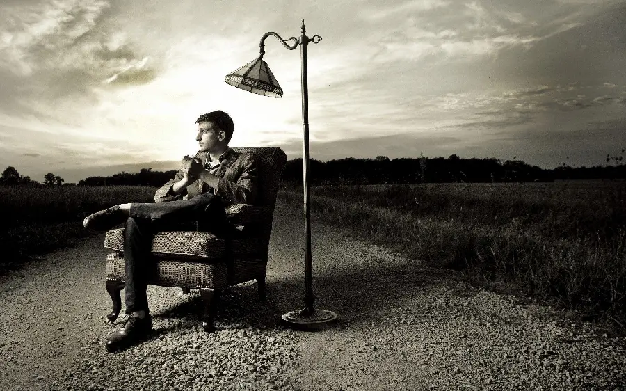 Artistic concept profile photo without text of a thoughtful man sitting on a chair