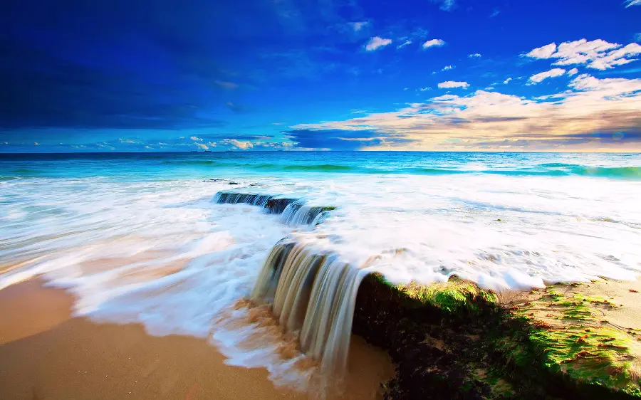 The latest image of the blue ocean with a beautiful sky and small waterfall rocks suitable for Instagram stories and posts