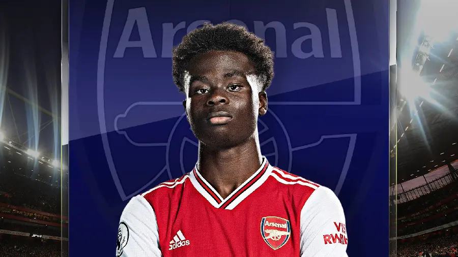 Official portrait of Bukayo Saka in Arsenal white and red kit