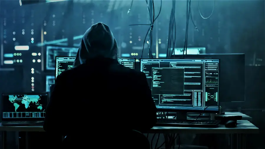 Photo of a hacker with a black hoodie behind the system hacking