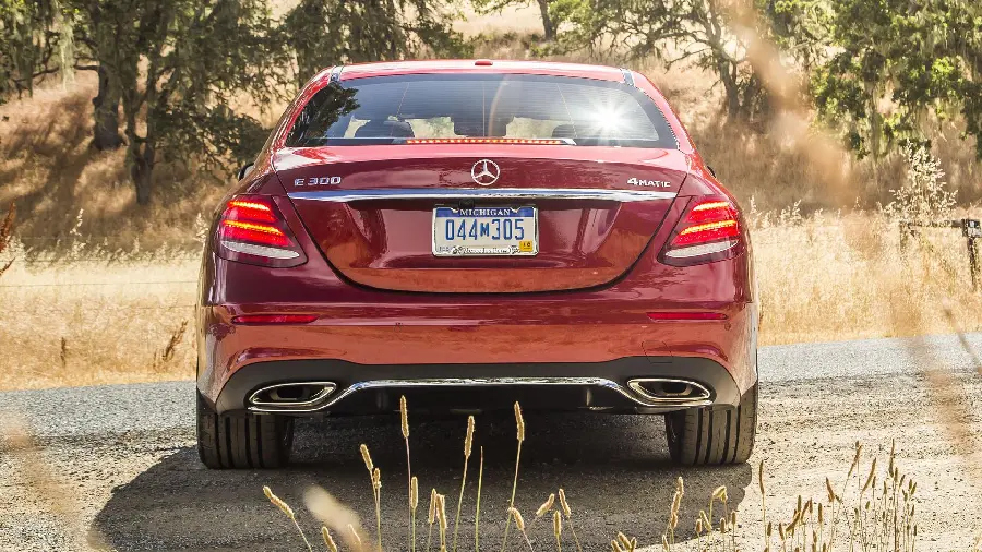 Beautiful and great view from the back of the cherry Mercedes-Benz E300 in the summer