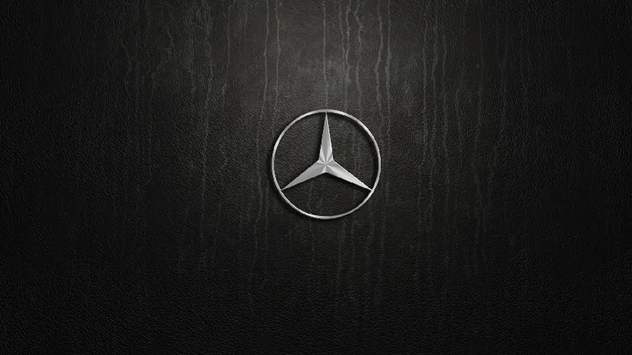 A background of a metal Benz car logo on a leather background