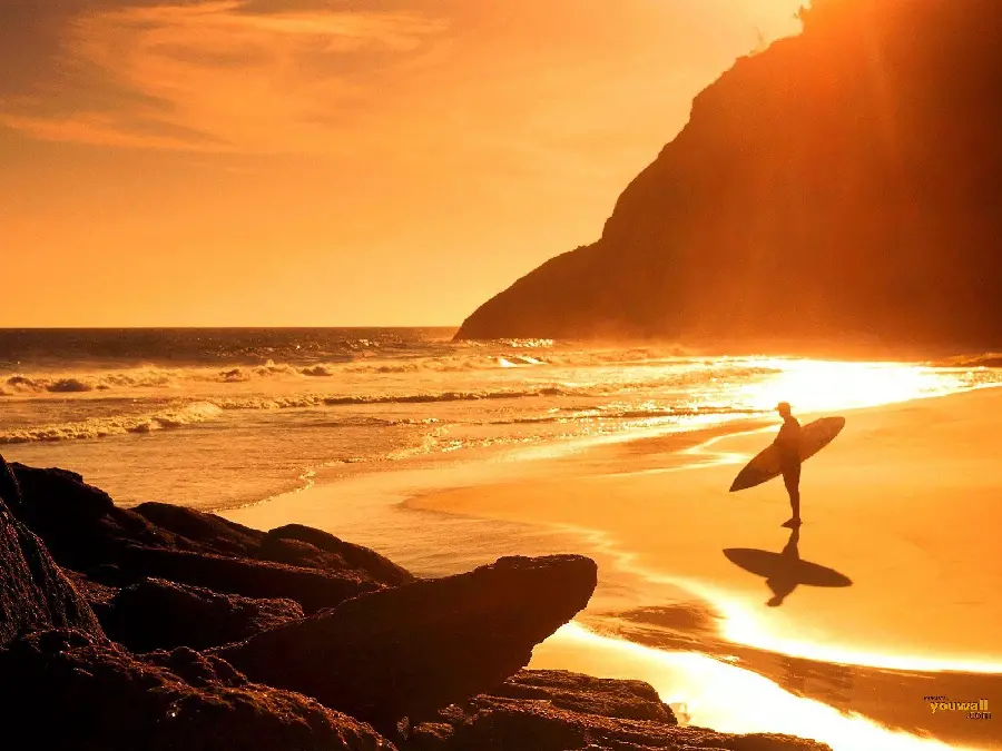 A very beautiful image of the ocean and a surfer at sunset
