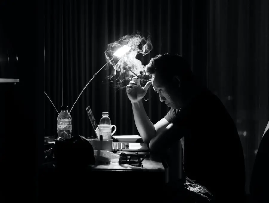 A conceptual artistic profile photo without text of a thoughtful and heavy man smoking a cigarette