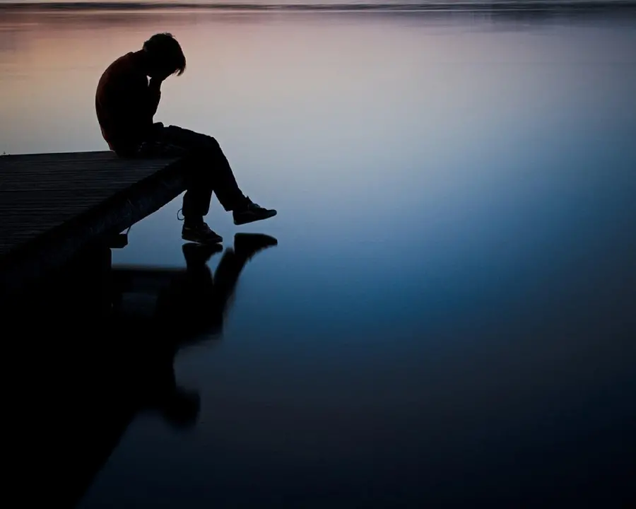 Profile photo of a thoughtful and loving man sitting on the pier