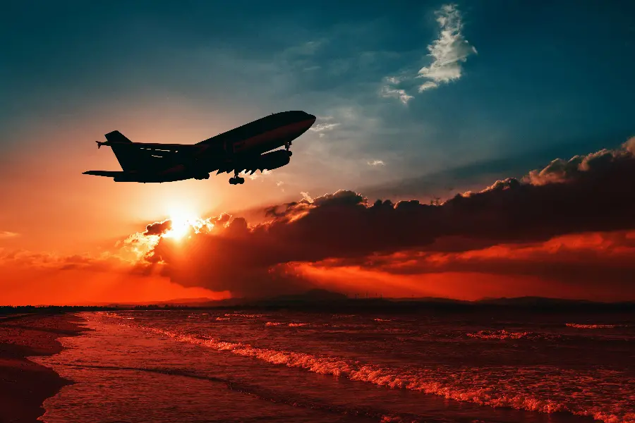 A mesmerizing image of a plane flying in the sunset sky with a combination of blue and orange colors suitable for a profile