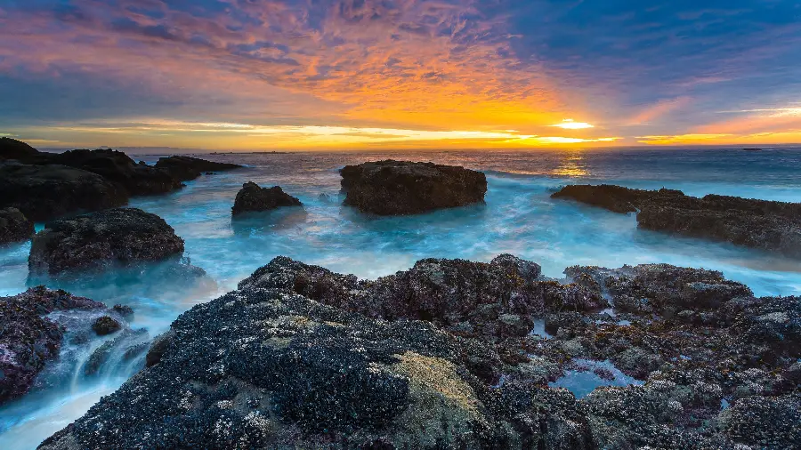 The best photo of the blue ocean sunset next to small and large rocks 1401