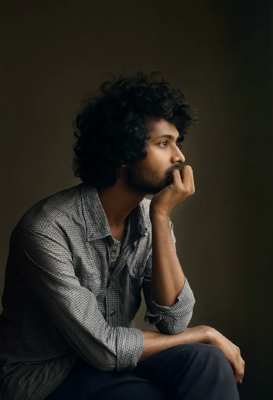 Close-up photo of a young thinking man on a colored background