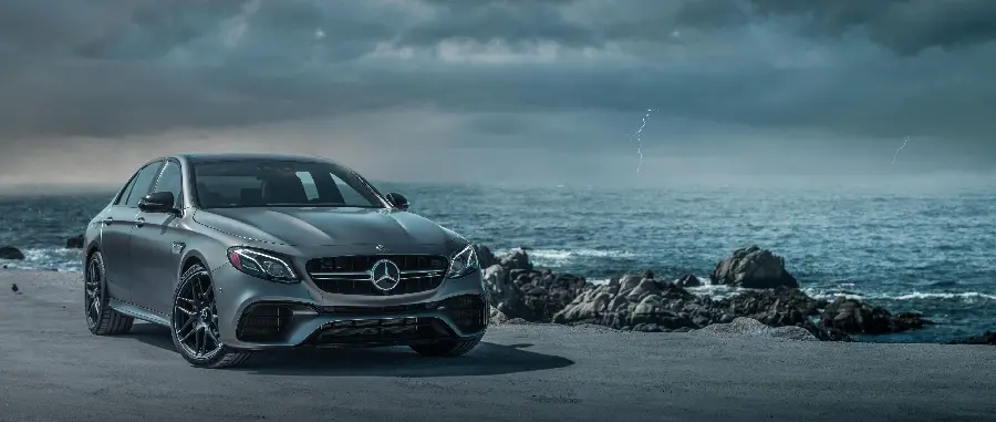 Background of silver Mercedes AMG E63 on the stormy sea shore