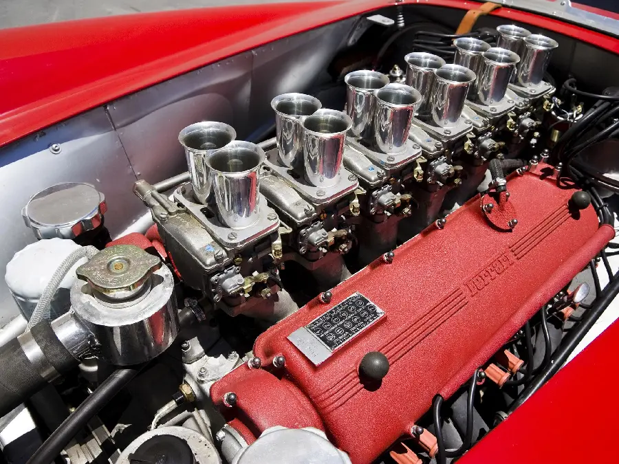 Photo of the inside of the 12-cylinder engine of a Ferrari sports car with a red shell