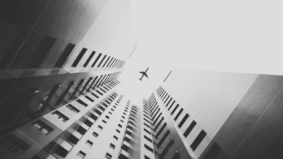 The most interesting black and white picture of a plane flying over tall buildings in HD quality