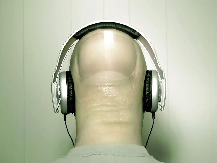Photo of a fingernail in the shape of a bald head with a hands-free
