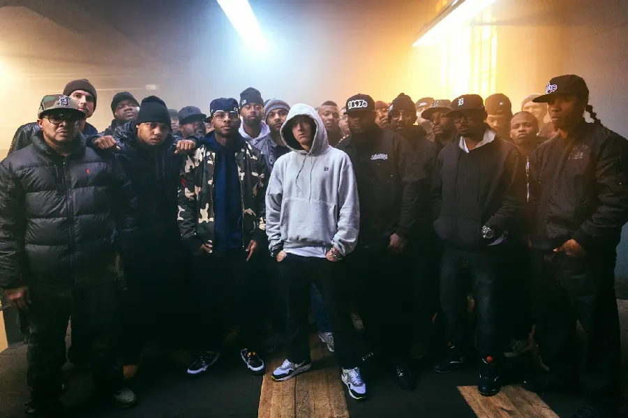Photo of Eminem with a large hoodie among the crowd of rappers
