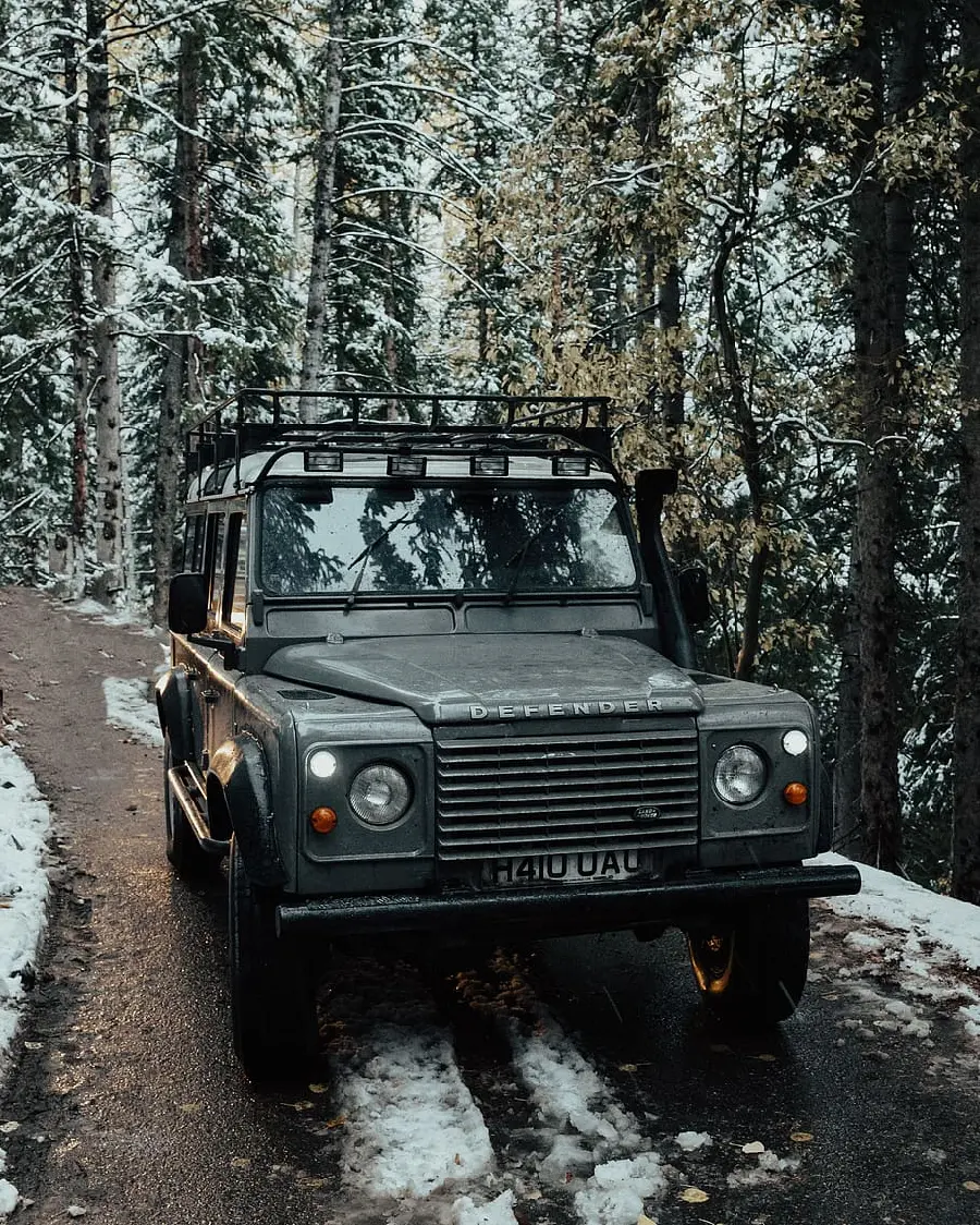 Download wallpaper of a cool and cool Land Rover car with gray color in a snowy forest