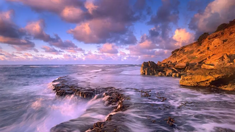 Download the image of the ocean next to the cliff and beautiful clouds with a wonderful color combination