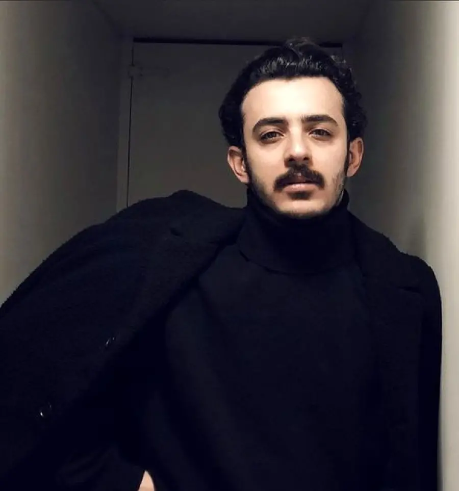 Full HD background of Ali Shadman with a beard and mustache and a black dress