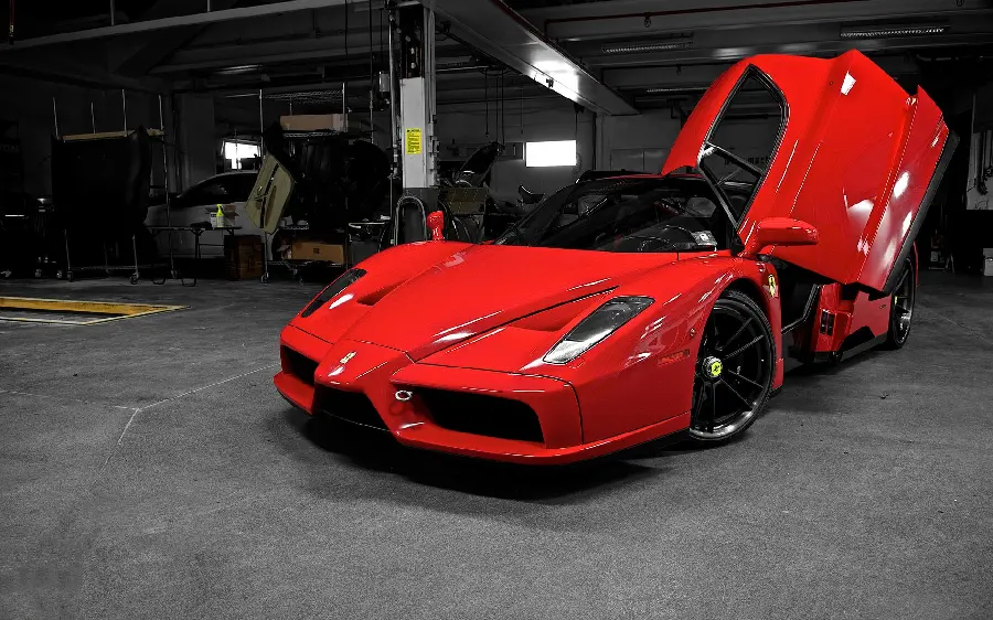 Stock photo and high-quality graphics of a Ferrari Enzo with an open door in a repair shop