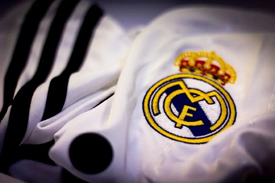 A unique background of the Real Madrid team uniform with the embroidered logo on it