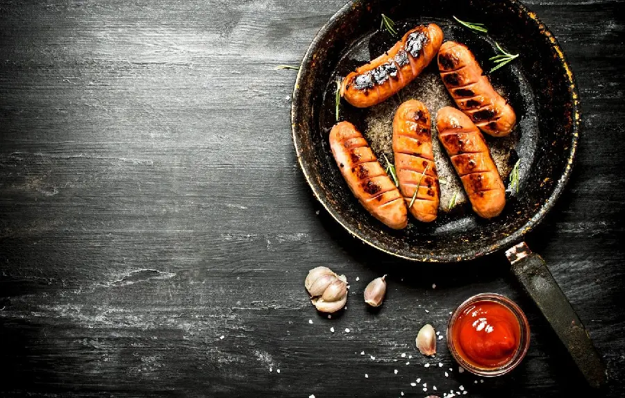 The latest background photo of Jamil's hot dog-shaped grilled chicken kebab in a pan with tomato sauce and a few cloves of garlic, special for Telegram