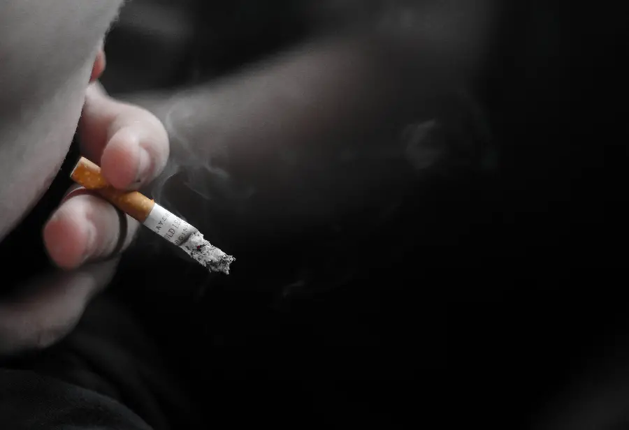 A special stock image of a hand near the mouth while smoking a cigarette