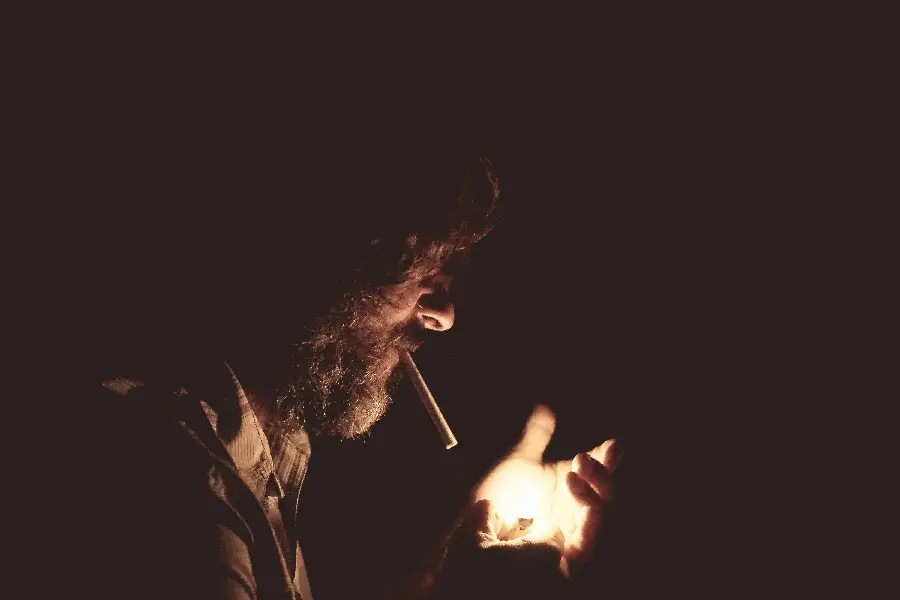 Download a stock image of a bearded and mustache-faced man lighting a lighter for a cigarette