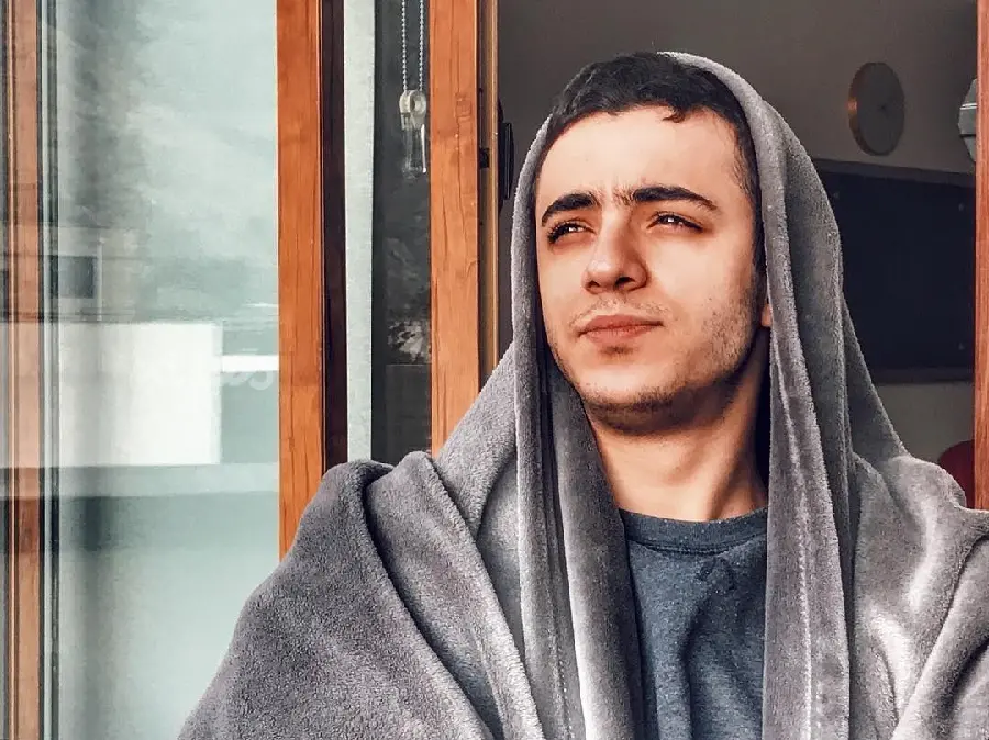 Ali Shadman staring with a blanket on his head background