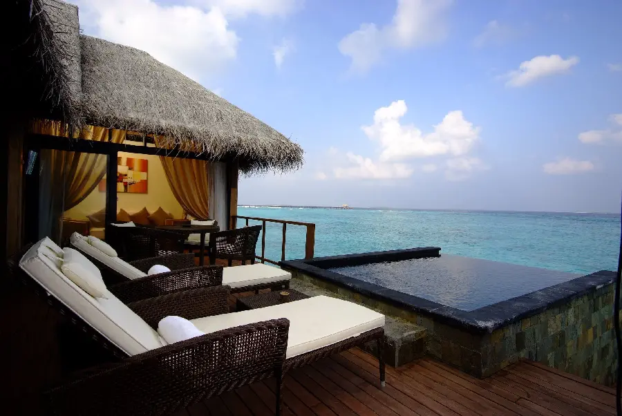 Download a pleasant background in high quality of a beach house villa and 2 sun loungers in front of the sea