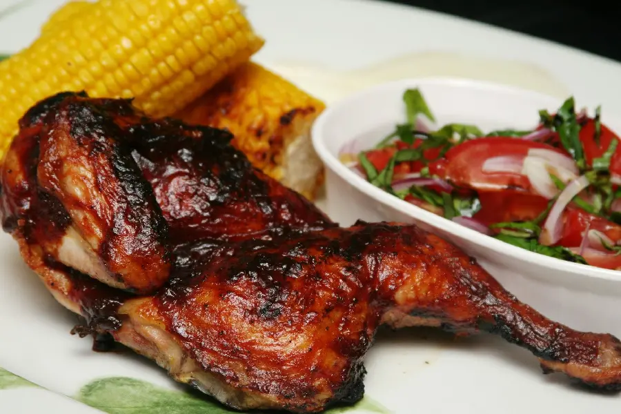 The latest background of a tender, well-roasted chicken thigh kebab with cobs and a light salad suitable for Instagram