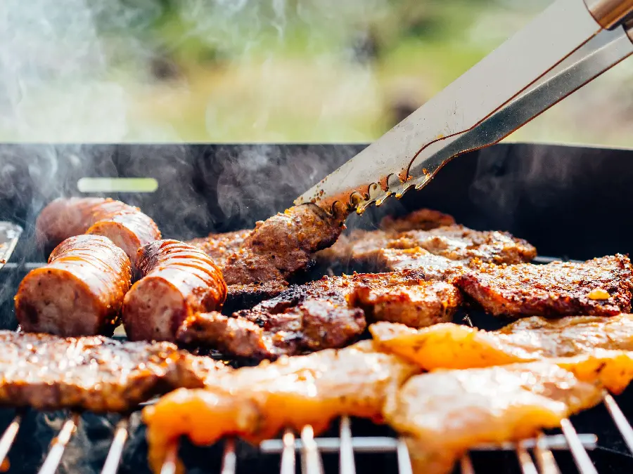 High-quality background of sausage, red meat and chicken pieces roasted on a special WhatsApp barbecue
