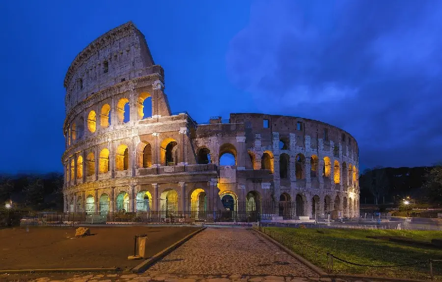 Night landscape background photo and special lighting effect of the Colosseum in Rome with blue sky