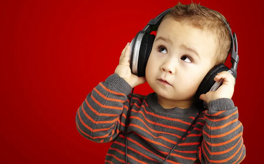 Photo of a cute little boy listening to headphones