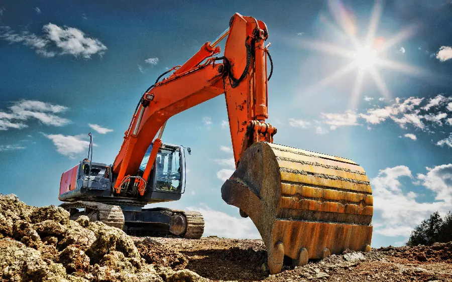 Interesting image of an orange excavator on a summer day