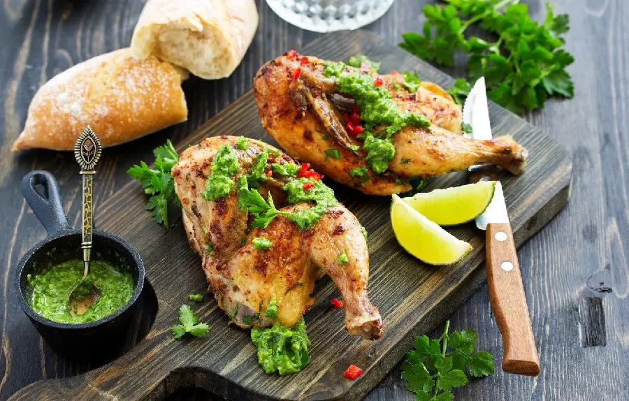 HD background of roasted chicken thighs with parsley sauce and fresh lemon suitable for Telegram