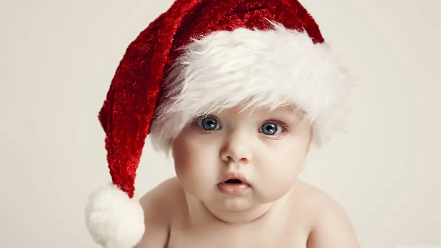 Full download background of a baby with a colored eye with a Christmas hat for laptops and computers 