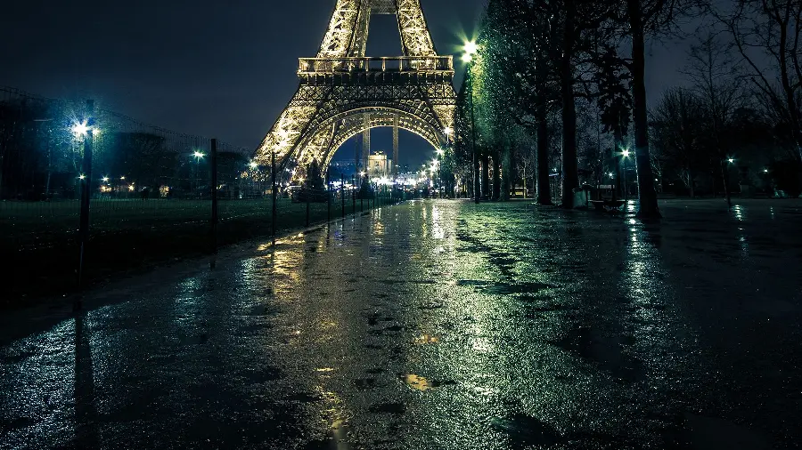Unfinished stock photo of the Eiffel Tower in rainy weather at night in the city of Paris, a symbol of French culture