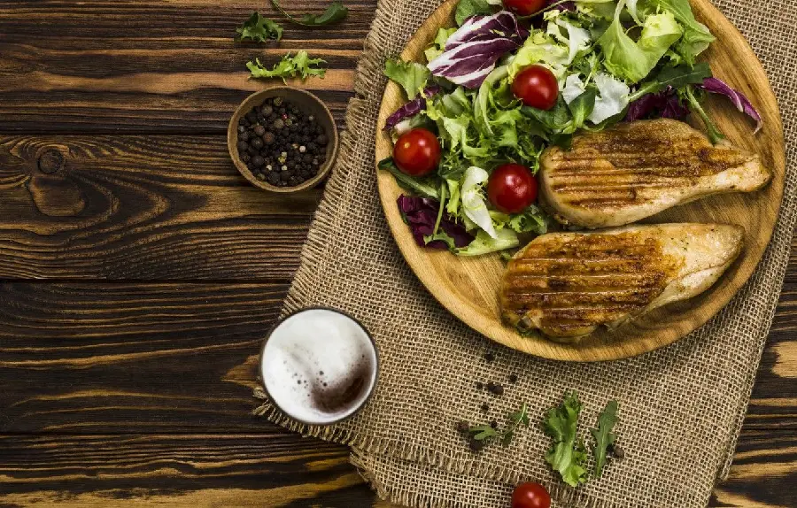 Great background image of two pieces of chicken cooked on the barbecue with seasonal salad