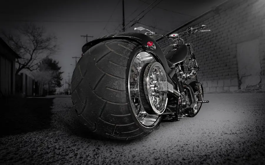 Strange background of the big tire on the back of a black motorcycle