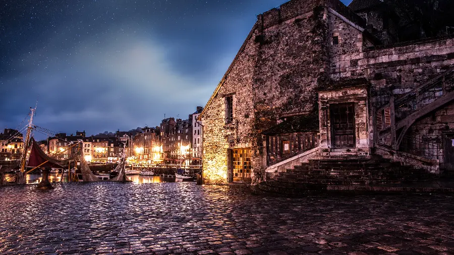 Download a stock photo of an ancient city by the water and full of light at night