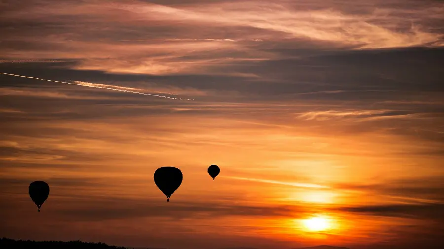 A spectacular photo of a sunset in nature and a photo of balloons flying in the sky in high quality