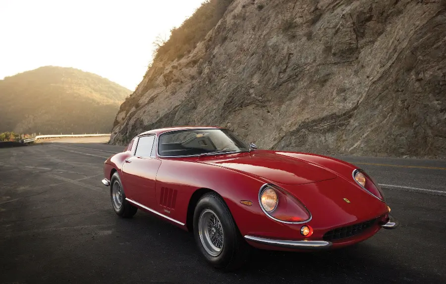 A spectacular image of an old and classic Ferrari with a special design Its lights on a mountain road in top quality