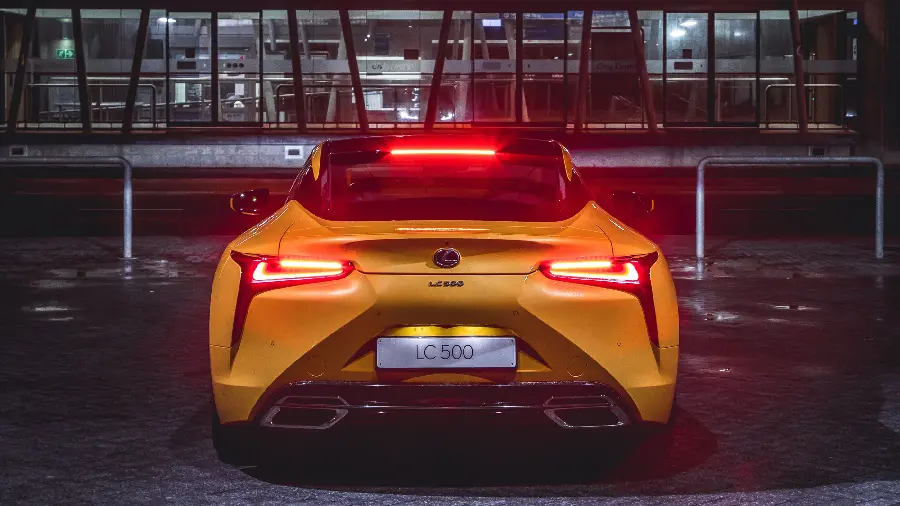 Download a beautiful picture of a Lexus LC 500 with bright lights in front of a building