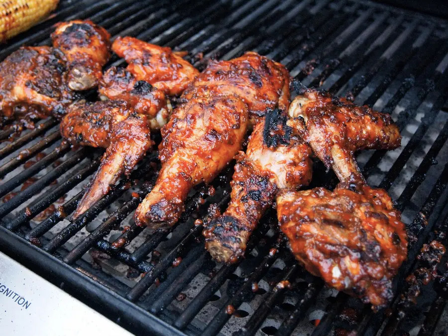 Photo of chicken pieces dipped in sauce on a barbecue for phone background