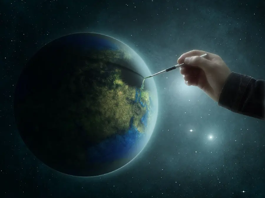 A strange graphic photo of the creation of the globe with a brush by a large hand